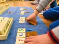 Dzieci bawią się koralikami i kartami z cyframi, ucząc się matematyki.